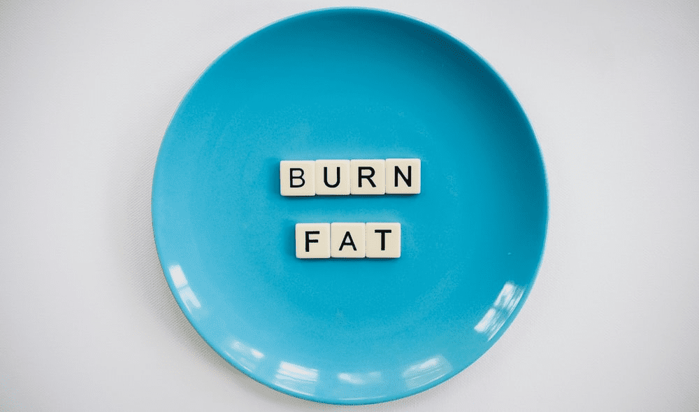 the phrase, ‘burn fat’ written with scrabble tiles on a plate 